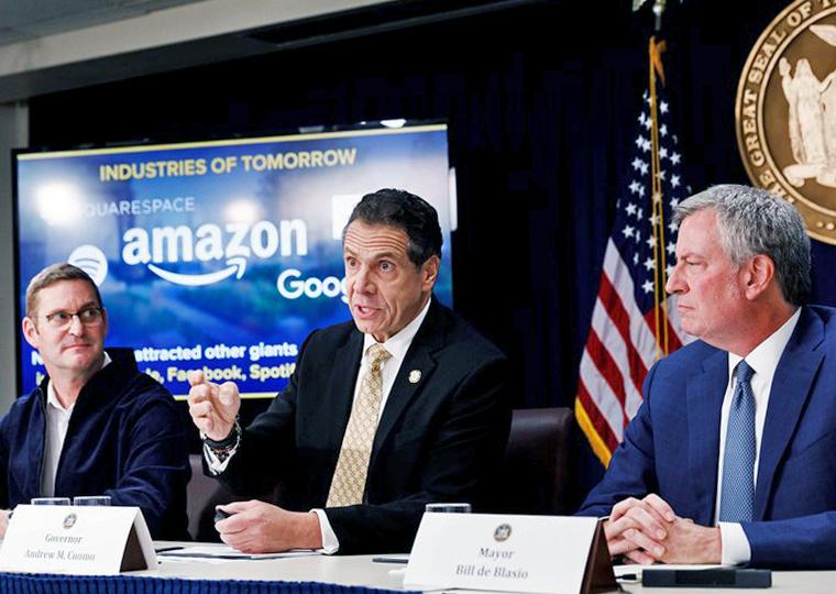 Gov. Andrew Cuomo (center) and Mayor Bill de Blasio (right) appear with Amazon real estate executive John Schoettler
