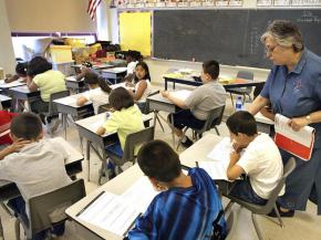 A teacher assists a student taking a test