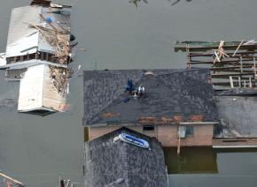 Stranded New Orleans residents sit on their roof in the wake of the Katrina disaster